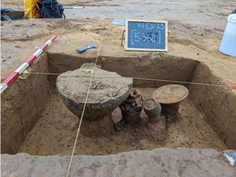 Showing cremation urns and other vessels in grave